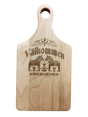 Maple wood cutting board (13.5" x 7") with handle, engraved Swedish folk art design, and “Valkommen” (Welcome in Swedish) at the center.
