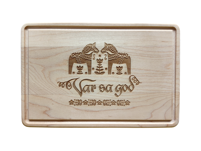 The Cutting Board: Var Sa God Maple Cutting Board (9"x6") features an engraved Scandinavian design and the phrase "Var så god" in script, making it a charming addition to any Scandinavian kitchen decor.