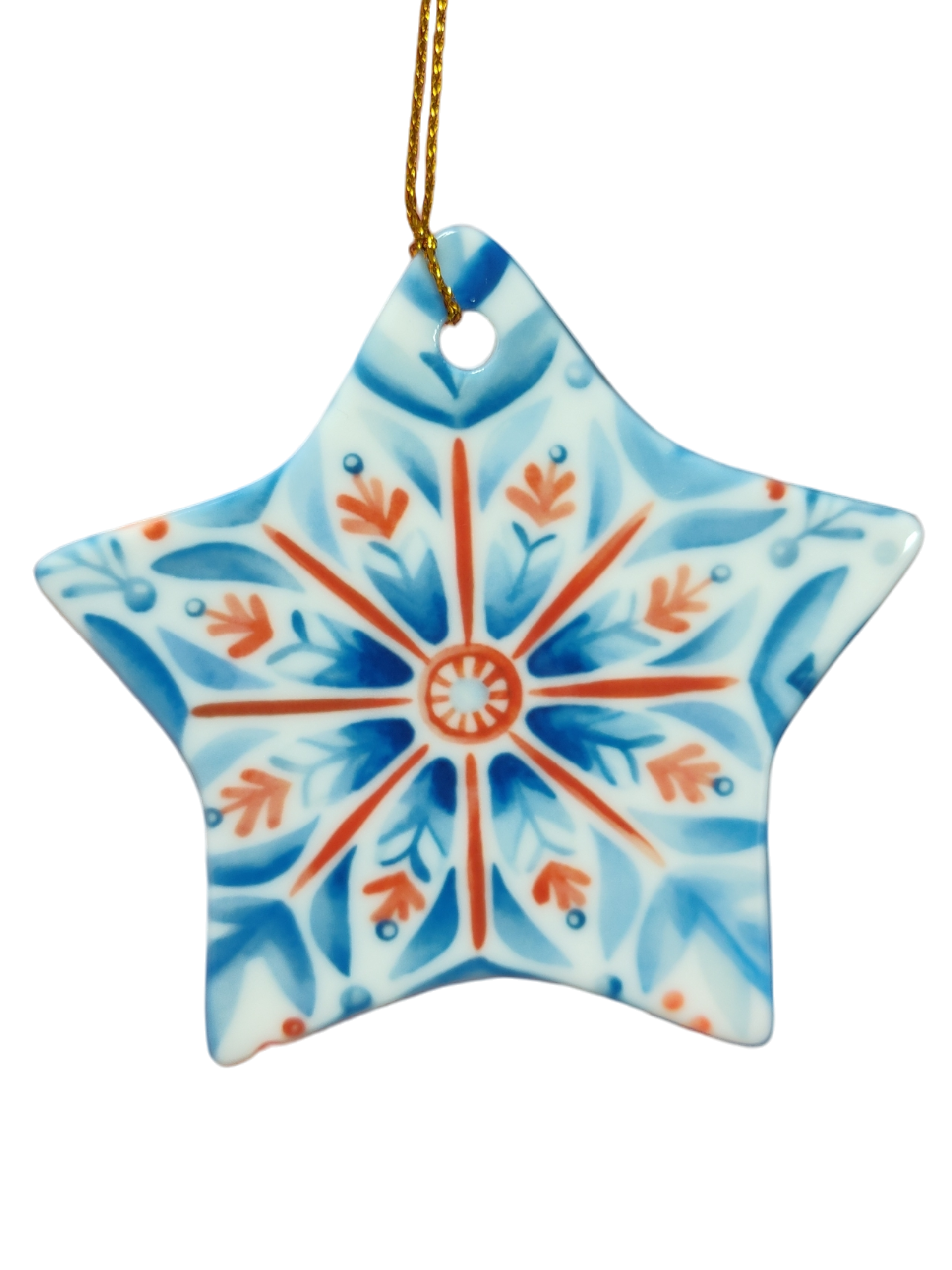 Red, white, and blue rosemaling star ceramic ornament hangs by a gold string against a white background—a charming piece of Scandinavian holiday décor.