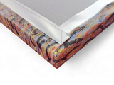 Close-up of a stretched "Café Terrace at Night" by Vincent Van Gogh canvas print, showing the vibrant colors and the neatly folded and stapled corner on its wooden frame.