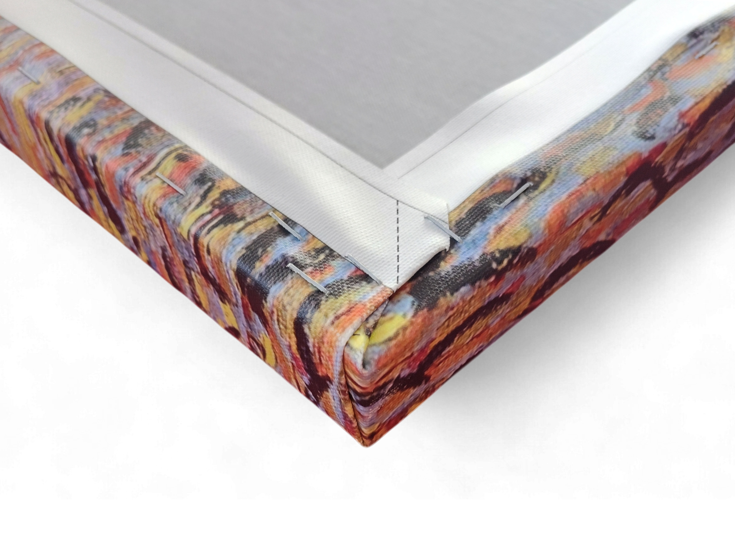 Close-up of a stretched "Café Terrace at Night" by Vincent Van Gogh canvas print, showing the vibrant colors and the neatly folded and stapled corner on its wooden frame.