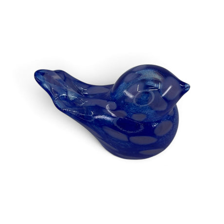 Small blue hand blown glass bird figurine with a glossy finish, shown on a white background from an angled top-down view.
