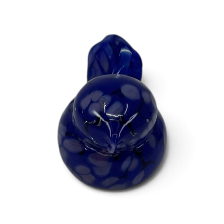 Hand blown glass bird figurine in deep blue with white speckles, shown from above on a white background.