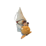 Scandinavian tomte girl figurine ornament wearing a felt hat and jacket, holding a fuzzy teddy bear and riding a wooden ski.