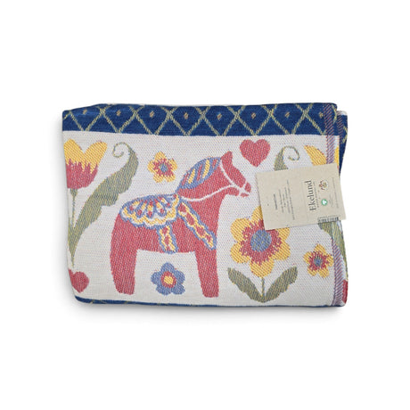 Folded woven blanket with a red Dala horse, colorful flowers, and a blue diamond border.