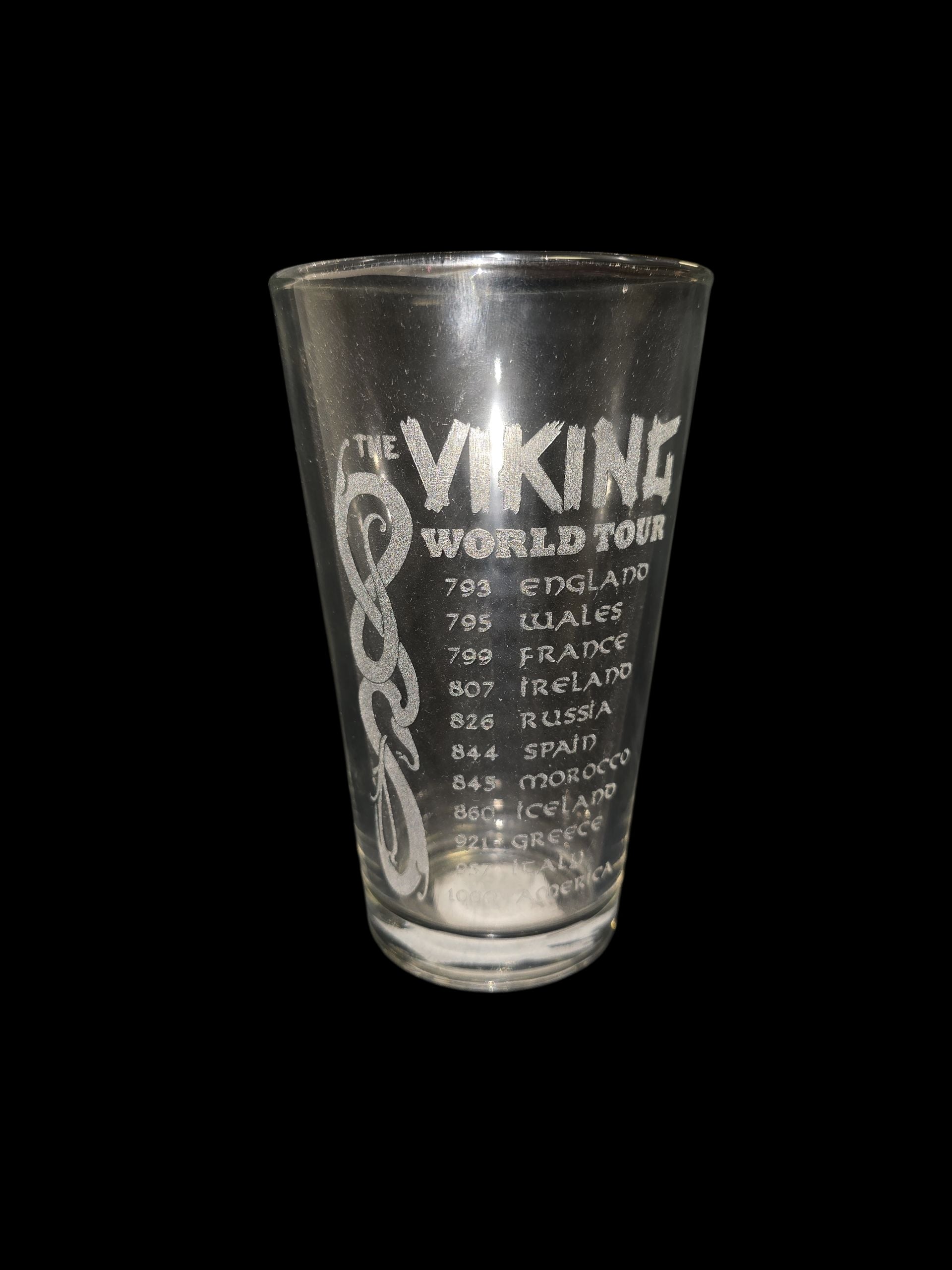 The "Viking World Tour" 16oz pint glass features a bold front engraving of years and countries, making it a unique piece of drinkware for any collection.