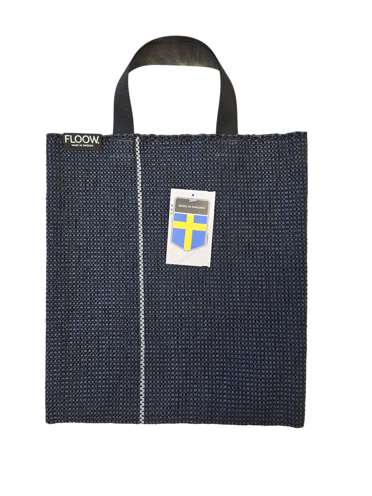 The Horredsmattan Floow Vinyl Bag (32x40cm) is a dark blue tote with black handles, a vertical white stripe, FLOOW. label, Swedish flag tag, and features the iconic Swedish vinyl rug design.
