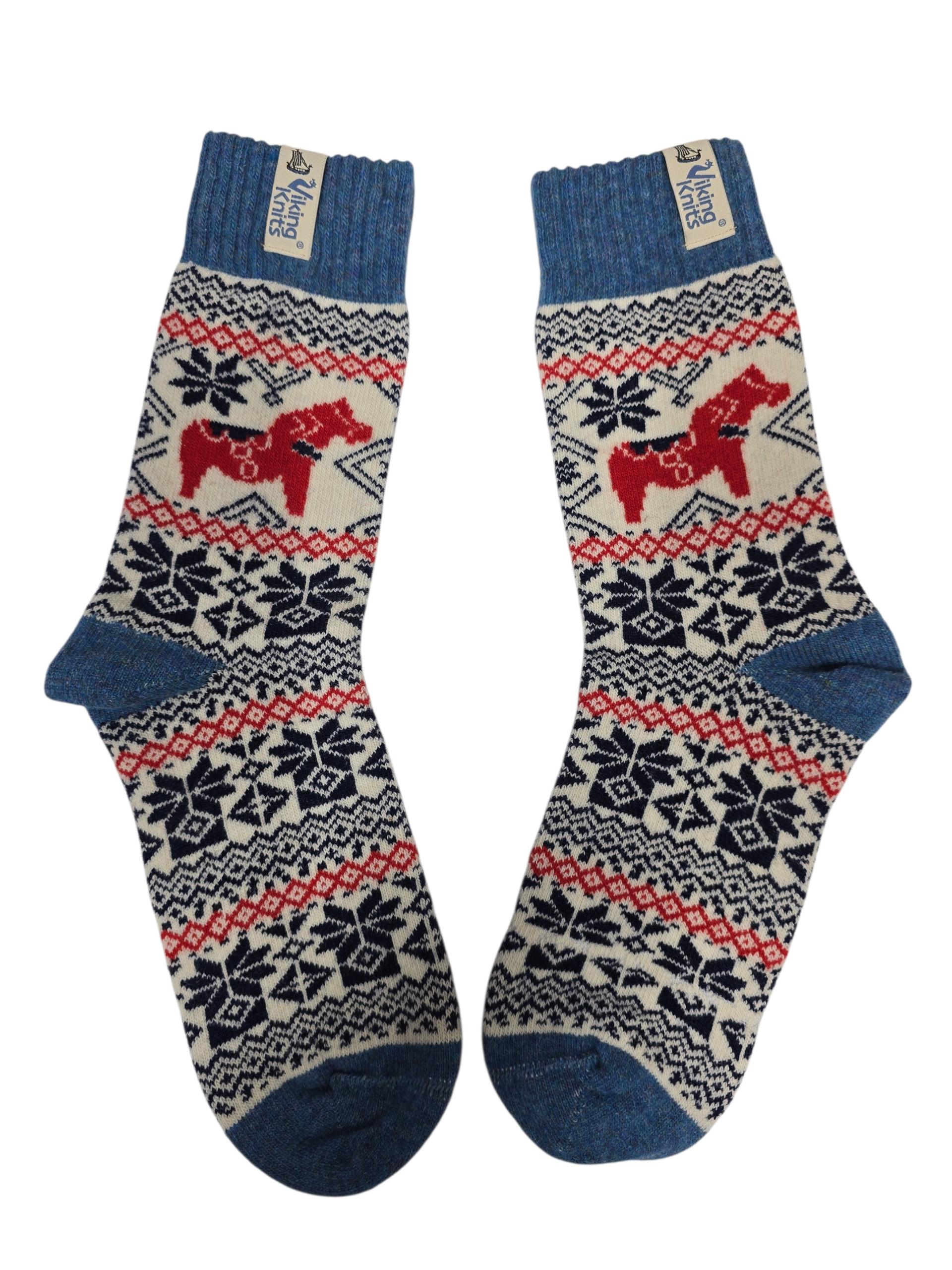 A pair of Viking Knits Dala Horse socks (60% wool) in blue and cream, featuring red horse and black snowflake patterns, laid flat side by side.