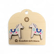 White Dala Horse stud earrings with colorful kurbits designs rest on a light card labeled Swedish Gift Store—perfect handcrafted Nordic accessories to add to your collection.