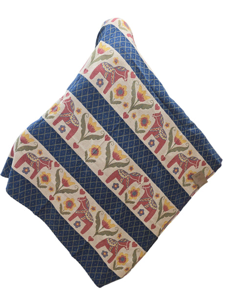 The Dala Horse 100% Cotton Woven Blanket by Ekelund of Sweden (55"x75") features blue diamond patterns with alternating rows of elephants, flowers, and leaves in red, yellow, and green.