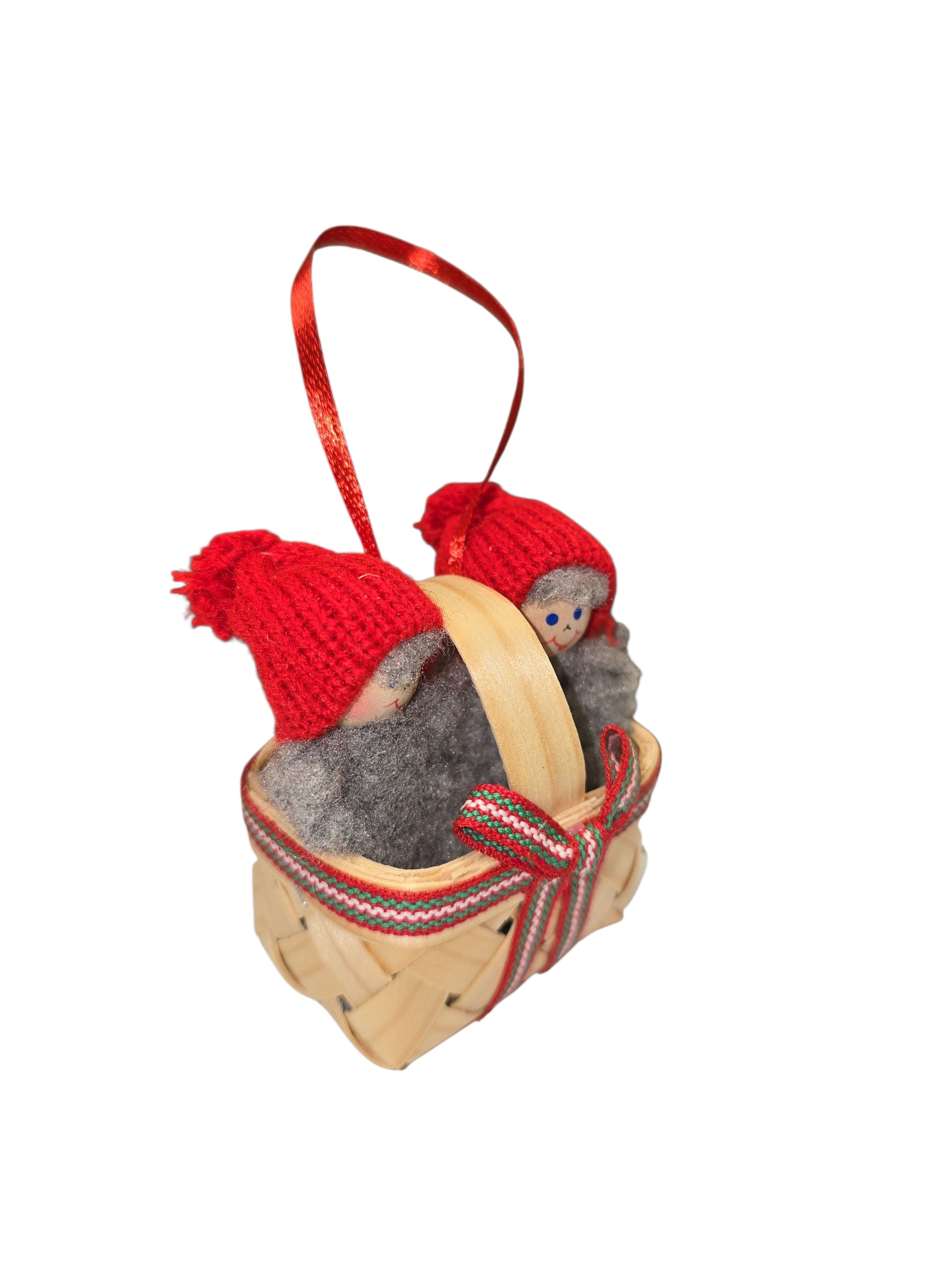 Ornament: Swedish Santa Figurines in a Basket features two Santas in red knit hats and gray outfits, nestled in a small woven basket with ribbon—a charming handmade Christmas decoration for any space.