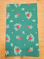 The "Jul Apple" table runner features red apples, green leaves, yellow stars, and woven Danish hearts on apple green cloth—perfect for Swedish Christmas decor. Measures 48" long and looks charming laid flat on your table.