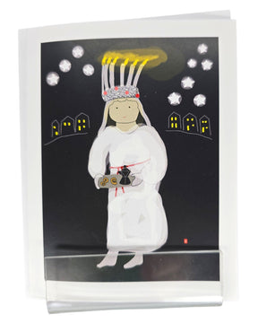 The Card: Lucia Greeting Card by Lisa Rydin Erickson features a girl in a white dress with a candle crown, holding pastries on a Fika tray, set among glowing houses—a charming Scandinavian holiday card. Blank inside with envelope included.