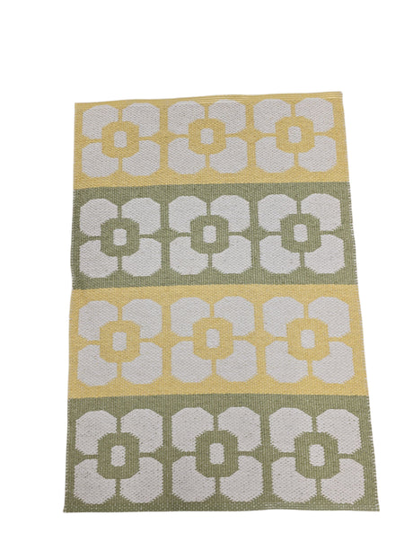 The Horredsmattan Florian Yellow, Green, & White vinyl rug features rows of white floral patterns on alternating yellow and green backgrounds—an eco-friendly Swedish rug that blends style with practicality.
