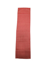 A "Norrland" reddish orange table runner with silver ice star patterns, measuring 48" long, displayed flat on a white background.