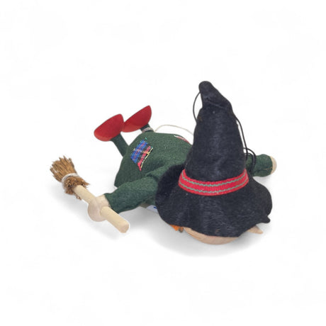 The Kitchen Witch Handcrafted Figurine, 4.5" long and made of wood and felt, wears green with a black hat and red shoes, holding a small broom—a delightful guardian for your kitchen.