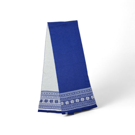 The Northern Story Setesday Royal Blue 100% Merino Wool Blue Scarf, featuring blue and white geometric and floral patterns inspired by Nordic Selbu star designs, is displayed upright against a plain white background.