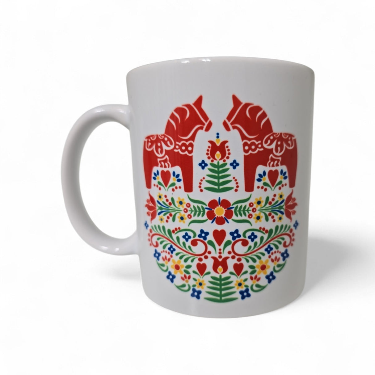 The “Mug: Two Red Dala Horses in a Field of Swedish Folk Flowers” from Swedish Gift Store is an 11oz white ceramic mug featuring two red horses and colorful Scandinavian folk art with vibrant floral patterns.