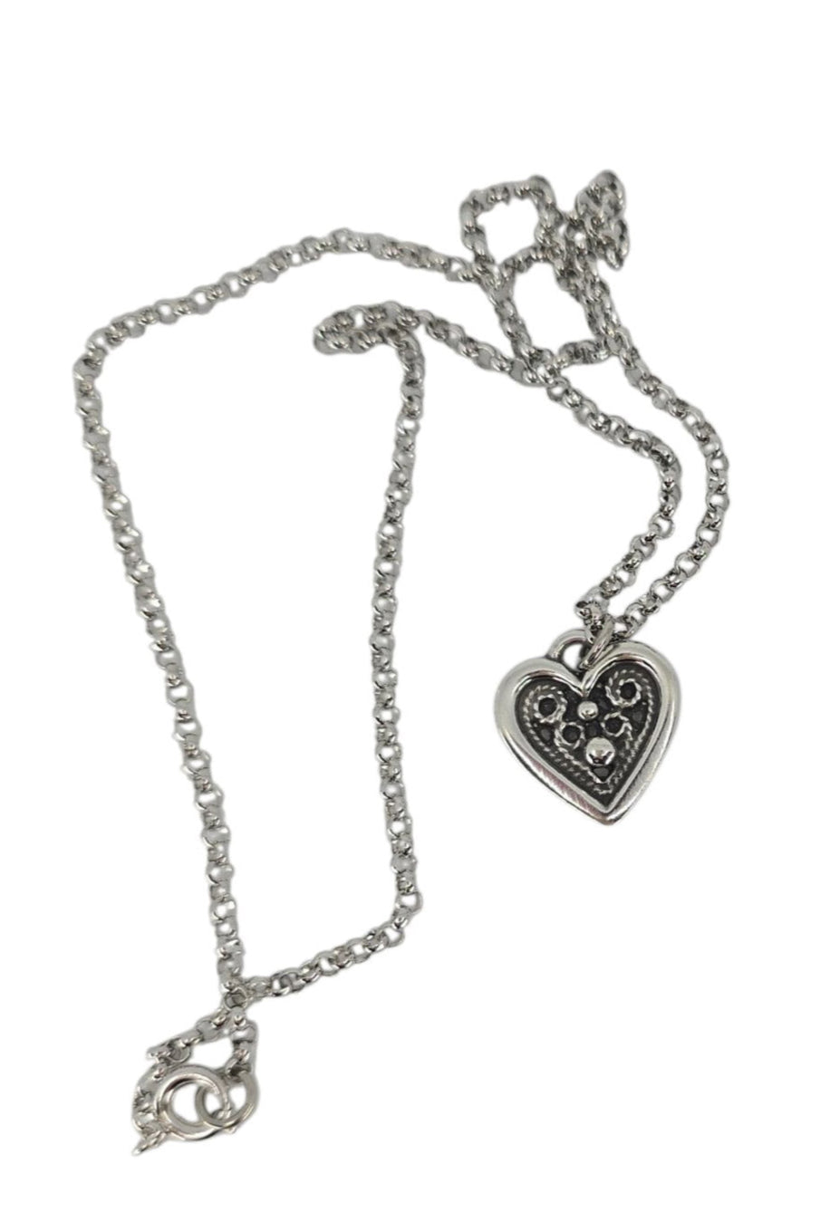 Silver necklace with a heart-shaped pendant on a white background