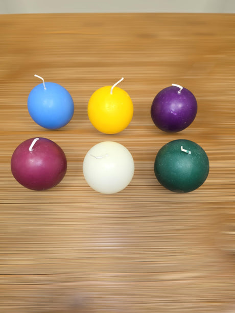 A 4-pack of Logum Kloster Lys 2.5" ball candles in assorted colors is arranged on a wooden surface, offering a stylish touch of Scandinavian décor to any room.