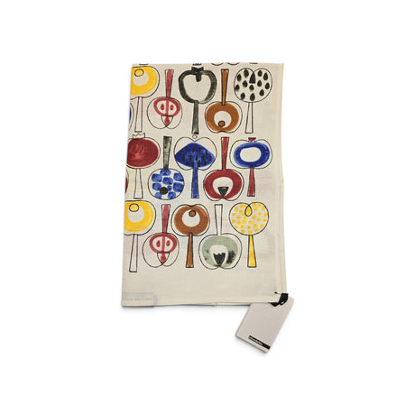 Folded beige tea towel with an abstract pattern of colorful circles and lines resembling trees, and a gray tag attached at one corner.