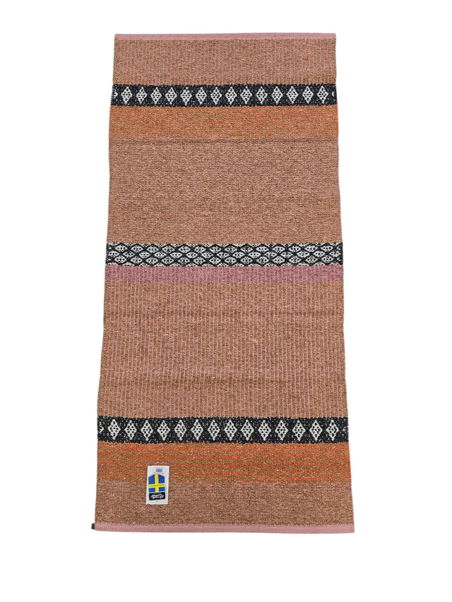 Cotton/Vinyl Rug: Horredsmattan - Forest - Rust features horizontal bands in brown, orange, pink, and black diamond patterns with a Swedish flag tag at the bottom left.