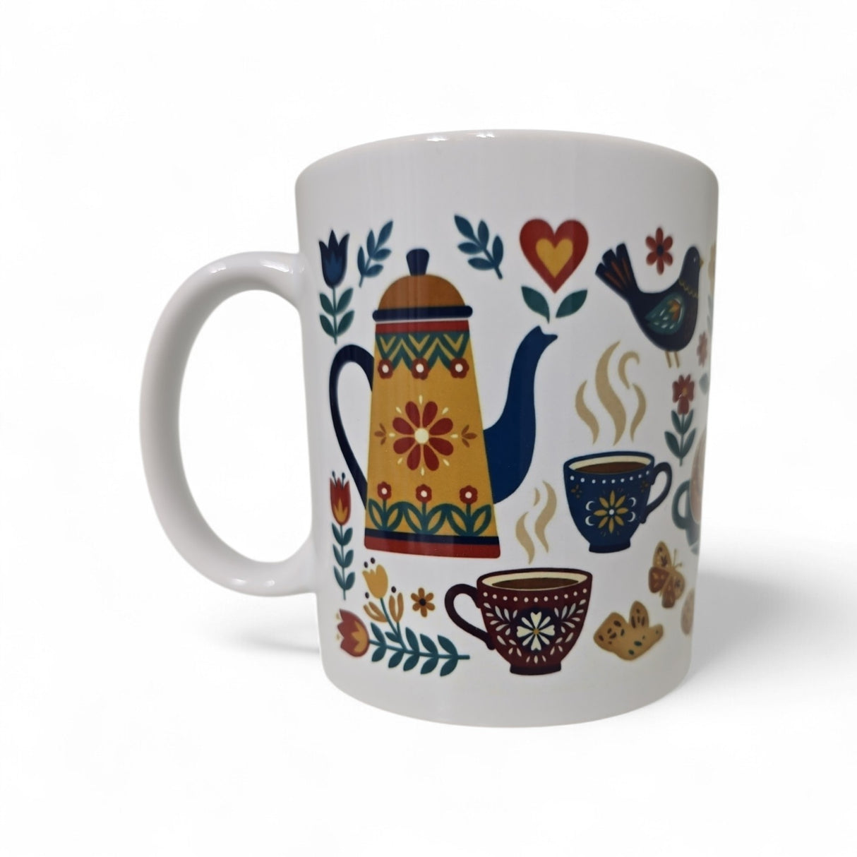 The "Mug: Fika — En Svensk Tradition Kaffepaus" from Swedish Gift Store is an 11oz white ceramic coffee mug with a colorful folk-art design of a teapot, steaming cups, flowers, bird, hearts, and cookies—perfect for a Swedish fika.