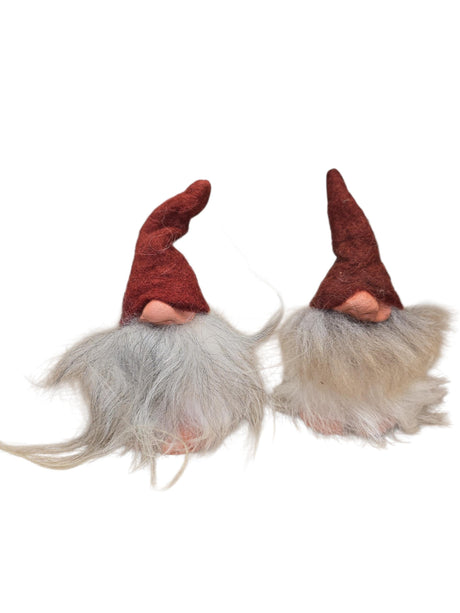 Two "Foot Tomte" gnome figurines by Gumselids of Sweden, each 6" tall with clay nose and feet, long gray sheep’s wool beards, tall red hats, and no visible eyes—set against a white background.