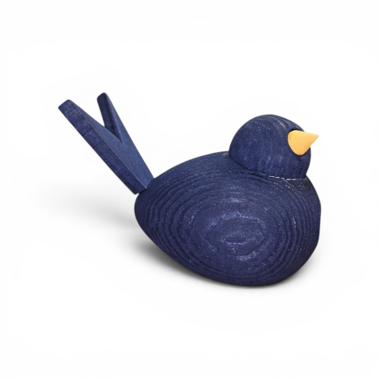 The Bergquist Imports Figurine: Wooden Scandi Birds Handcrafted Figurines from Sweden (3" long) features a dark blue body, yellow beak, and simple Nordic design, beautifully displayed on a white background.