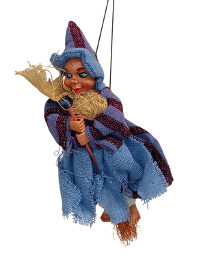 The Kitchen Witch: Philippa Blue Kitchen Witch Doll, handmade in Germany, features a blue outfit and hat with a broomstick. Suspended by a string against a white background, it’s a charming good luck charm for any home.