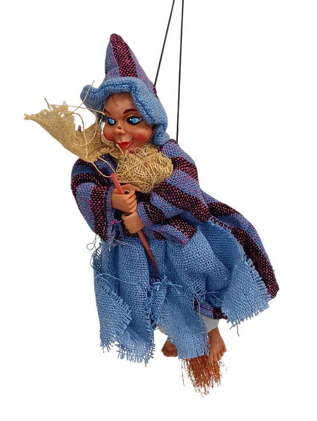 The Kitchen Witch: Philippa Blue Kitchen Witch Doll, handmade in Germany, features a blue outfit and hat with a broomstick. Suspended by a string against a white background, it’s a charming good luck charm for any home.