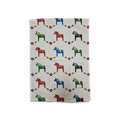 Cream-colored cotton kitchen towel with a repeating pattern of colorful Dala horses and small red floral motifs.