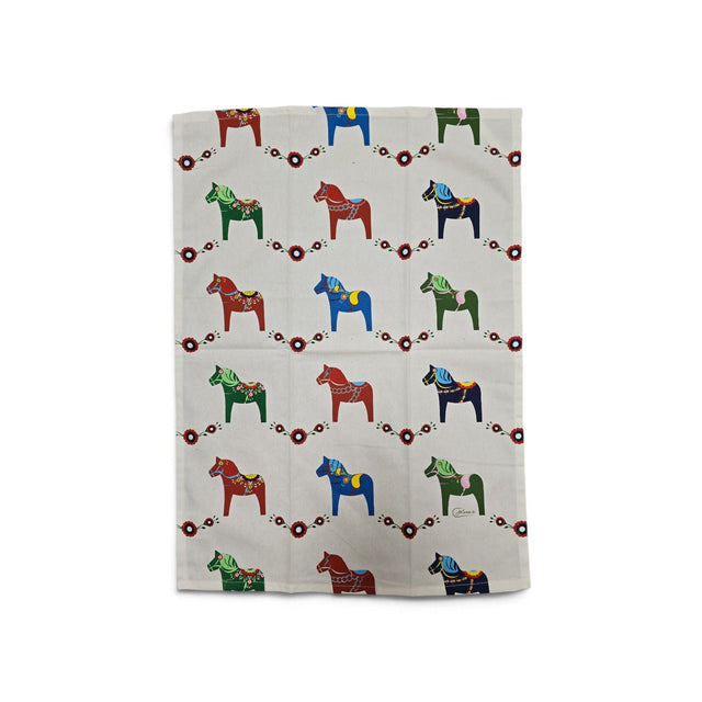 Cream-colored cotton kitchen towel with a repeating pattern of colorful Dala horses and small red floral motifs.