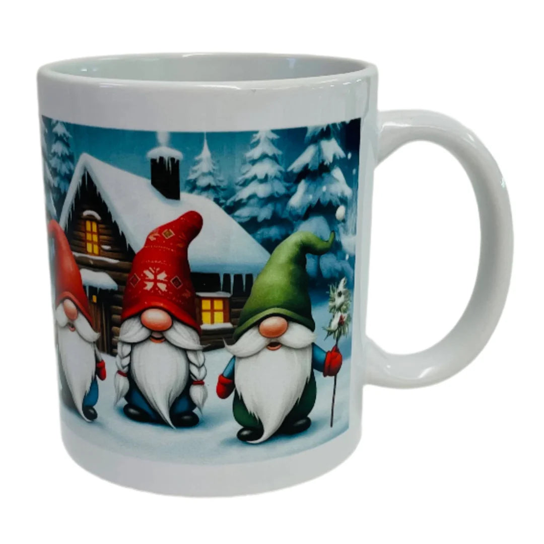 The Mug: Three Gnomes Coffee Mug showcases three bearded gnomes in festive hats, set before a snowy cabin and pine trees—an ideal winter mug for your morning coffee.