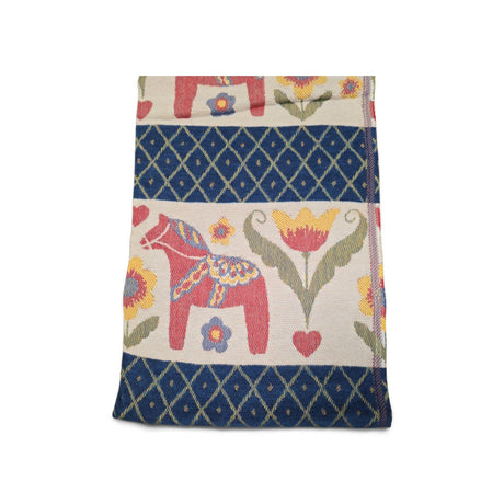 Folded woven cotton throw featuring a Dala horse, floral motifs, and a blue diamond lattice pattern.