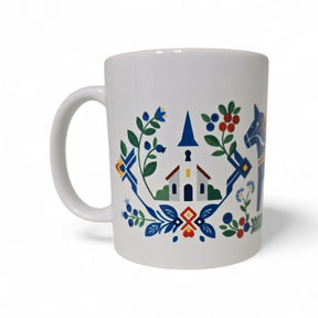 The Swedish Gift Store’s 11oz ceramic mug features a blue Dala horse, church with blue steeple, and red house in colorful Scandinavian folk art style.