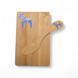 The Board & Spreader: Blue Dala Horse Alder Sandwich Board and Spreader set features an eco-friendly serving board and butter knife with a blue Swedish Dala Horse design, shown on a white background.