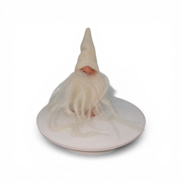 The "Foot Tomte" gnome figurine by Talla Imports, handcrafted by Gumselids of Sweden, features a tall white hat, long white beard, clay nose and feet, and sits on a round white platform against a plain white background.