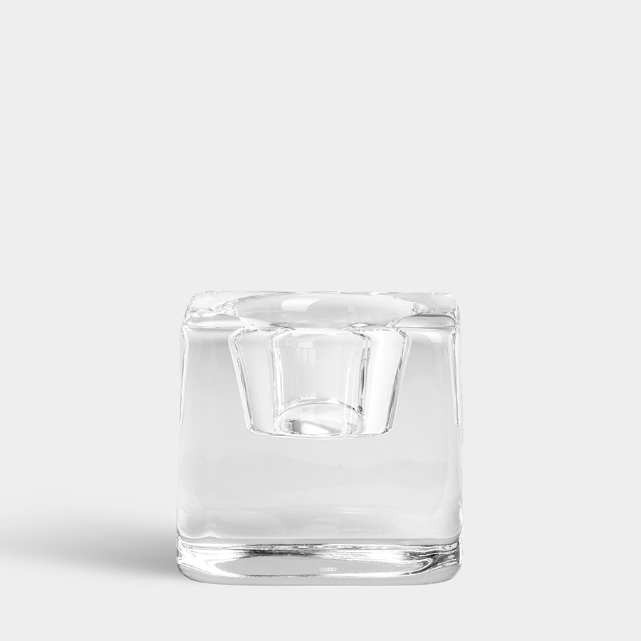 The Orrefors Ice Cube Votive Candle Holder by Goran Warff, a clear square crystal design evoking an ice cube, is displayed against a plain light gray background.