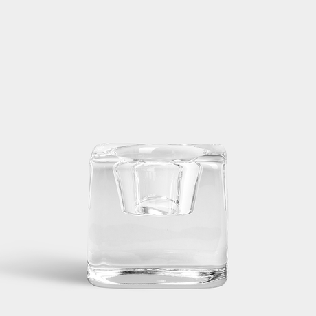 The Orrefors Ice Cube Votive Candle Holder by Goran Warff, a clear square crystal design evoking an ice cube, is displayed against a plain light gray background.