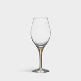The Orrefors: Intermezzo Gold Balance Glass 14.8oz (2-Pack) features an elegant gold-tinted stem that exemplifies the series charm, enhancing any table setting against a plain white backdrop with its balanced design and craftsmanship.