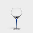 The Orrefors Intermezzo Blue Bouquet Glass 20oz, designed by Erika Lagerbielke, features clear glass with a rounded bowl and a slender blue stem, shown upright against a plain white background.