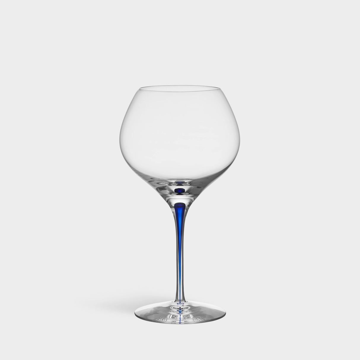 The Orrefors Intermezzo Blue Bouquet Glass 20oz, designed by Erika Lagerbielke, features clear glass with a rounded bowl and a slender blue stem, shown upright against a plain white background.