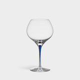 The Orrefors Intermezzo Blue Bouquet Glass 20oz, designed by Erika Lagerbielke, features clear glass with a rounded bowl and a slender blue stem, shown upright against a plain white background.