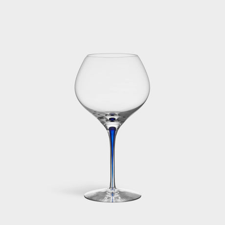 The Orrefors Intermezzo Blue Bouquet Glass 20oz, designed by Erika Lagerbielke, features clear glass with a rounded bowl and a slender blue stem, shown upright against a plain white background.