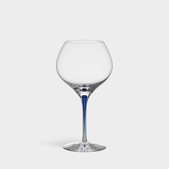 The Orrefors Intermezzo Blue Bouquet Glass 20oz, designed by Erika Lagerbielke, features clear glass with a rounded bowl and a slender blue stem, shown upright against a plain white background.