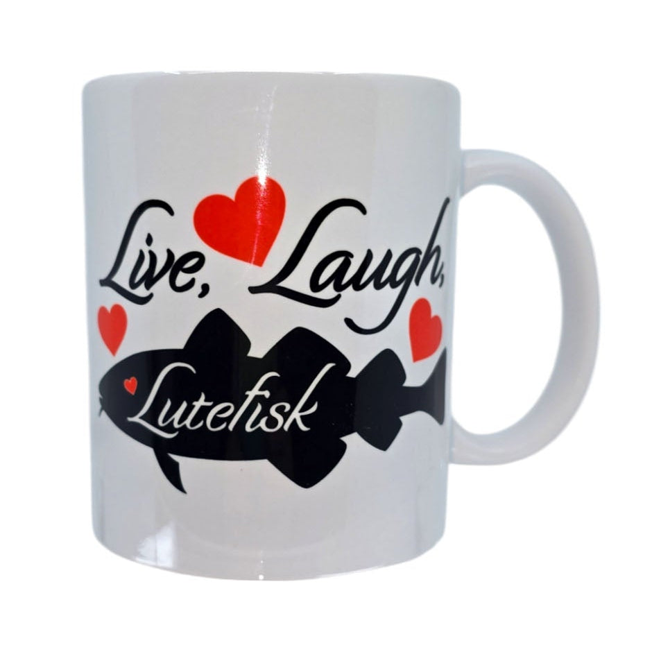 The Mug: Live Laugh Lutefisk is a white ceramic mug featuring a black fish silhouette, red hearts, and the phrase Live, Laugh, Lutefisk in decorative font—an ideal whimsical gift for Swede enthusiasts.