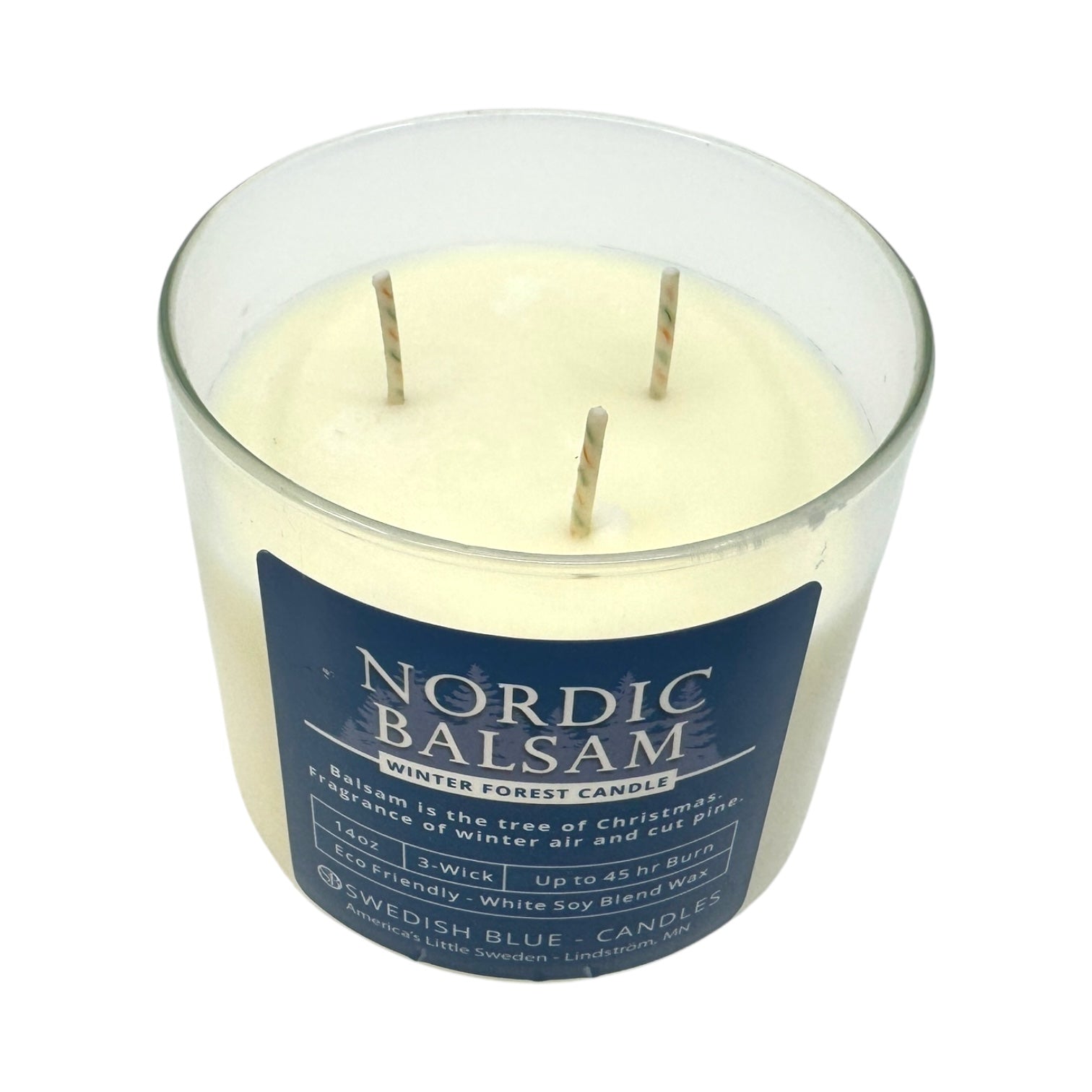 A three-wick white soy blend candle in a clear glass jar labeled Candle: Nordic Balsam - Winter Forest Candle by Swedish Blue Candles.