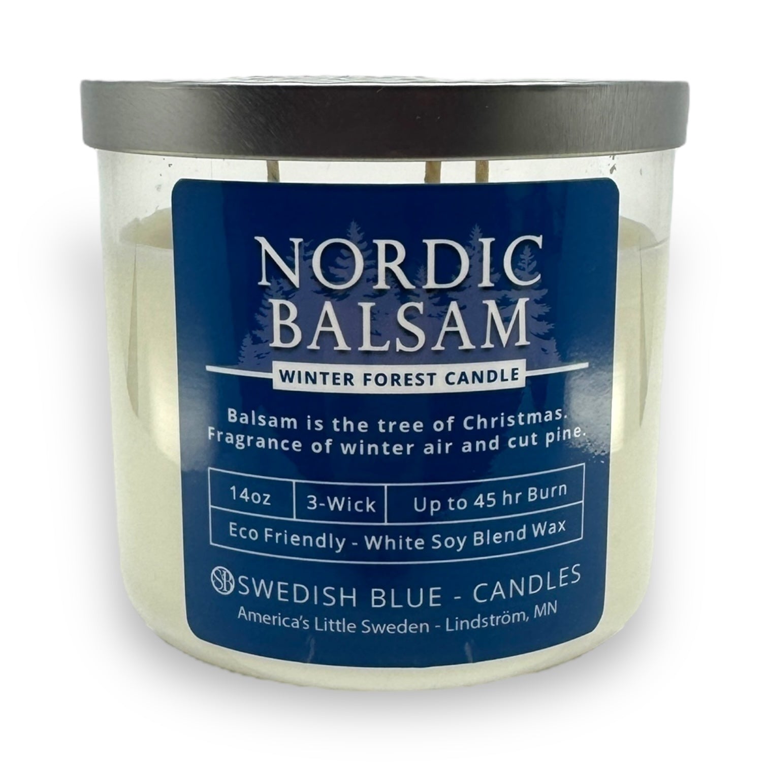The Candle: Nordic Balsam - Winter Forest Candle is a 14oz, three-wick candle with white soy blend wax and a blue label detailing its balsam fir fragrance and burn time.