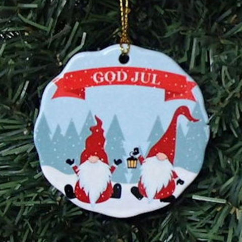 The tree is adorned with a porcelain Christmas ornament, carefully hand-cut and featuring the "GOD JUL Gnomes in the Snow," showcasing two gnomes in red hats holding a lantern and "God Jul" written above them.